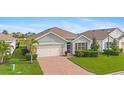 Single-story home with a brick driveway and palm trees at 3861 Cobblestone Ln, Port Charlotte, FL 33980