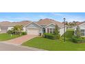 House exterior showcasing a green facade, brick pavers, and lush landscaping at 3861 Cobblestone Ln, Port Charlotte, FL 33980