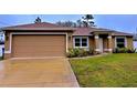 Front view of a house with a two-car garage and landscaping at 6208 Keating Ave, North Port, FL 34291