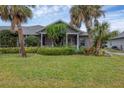 Bright gray house with a screened porch and palm trees at 1259 Red Oak Ln, Port Charlotte, FL 33948