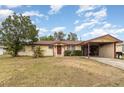 Ranch-style home with carport, spacious lawn, and red door at 168 Dartmouth Nw Dr, Port Charlotte, FL 33952