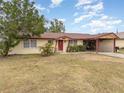 Ranch-style home with carport, spacious lawn, and red door at 168 Dartmouth Nw Dr, Port Charlotte, FL 33952