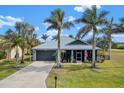 Single-story house with metal roof, gray exterior, and palm trees at 17654 Vellum Cir, Punta Gorda, FL 33955