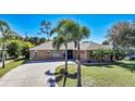 Single-story home with a curved driveway and palm trees at 18395 Edgewater Dr, Port Charlotte, FL 33948