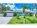 Charming single-story home with a gray roof, stone facade, and lush green lawn at 192 Danforth S Dr, Port Charlotte, FL 33980