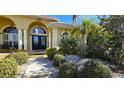 Front entrance with double doors, columns, and lush landscaping at 220 Shreve St, Punta Gorda, FL 33950