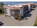 Condo building's exterior, showing parking and landscaping details from an aerial perspective at 25188 Marion Ave # E103, Punta Gorda, FL 33950