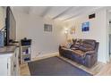 Cozy living room featuring a comfortable brown sofa, TV, and laminate wood floor at 2763 Woodgate Ln # 206, Sarasota, FL 34231