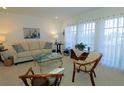 Light beige living room with a large window, comfortable seating, and a coffee table at 3000 Peace River Dr, Punta Gorda, FL 33983