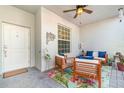 An outdoor living space with two chairs and a sofa are decorated with colorful pillows and a palm tree rug at 43996 Boardwalk Loop # 1411, Punta Gorda, FL 33982