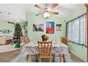 Bright dining room with a floral tablecloth, wooden chairs, and a Christmas tree at 483 Winwood Ct, Port Charlotte, FL 33954