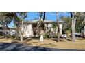 Front view of condo building showcasing landscaping and a tree-lined street at 1051 Forrest Nelson Blvd # A-104, Port Charlotte, FL 33952