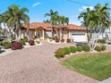 Beautiful waterfront home with a tile roof, lush landscaping, and a brick driveway at 1460 Raven Ct, Punta Gorda, FL 33950