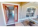 Inviting entryway with an orange door and tiled floor at 16129 Coruna Ct, Punta Gorda, FL 33955