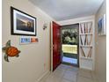 Bright entryway with red door, tiled floors, and decorative wall art at 19071 Helena Ave, Port Charlotte, FL 33948