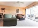 Living room with green sofa, leather love seat and access to balcony overlooking water at 19375 Water Oak Dr # 203, Port Charlotte, FL 33948