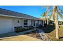 White house with a grey roof, palm trees, and a walkway at 25075 Palisade Rd, Punta Gorda, FL 33983