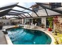 Inviting kidney shaped pool with covered patio and lush landscaping at 25188 Marion Ave # 12, Punta Gorda, FL 33950