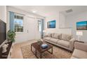 Inviting living room featuring a comfortable couch, stylish rug, and bright, airy windows at 27066 Sumatra Dr, Punta Gorda, FL 33955