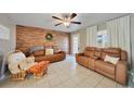 Living room featuring brown leather couches and a wood-look accent wall at 27131 Ann Arbor Ave, Punta Gorda, FL 33983