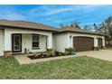 Front entry with a three-car garage and paver driveway at 3495 Levee St, North Port, FL 34288