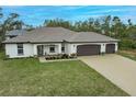 House with a three-car garage and paver driveway at 3495 Levee St, North Port, FL 34288