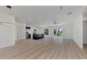 Open concept living room and kitchen with light wood floors and ceiling fan at 5049 Birdsong St, North Port, FL 34291