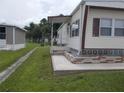 Side view of mobile home showing steps and landscaping at 5733 Holiday Park Blvd, North Port, FL 34287