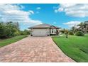 One-story house with gray roof and brick paver driveway at 102 Linda Lee Dr, Rotonda West, FL 33947