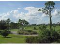 Landscaped golf course with pond and mature trees at 13147 Preserve Ct, Port Charlotte, FL 33953