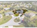 Aerial view of a home in a quiet cul-de-sac surrounded by lush landscaping and neighborhood streets at 154 Catamaraca Ct, Punta Gorda, FL 33983