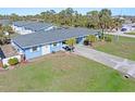 Aerial view of a light blue single-story home with a large yard and palm trees at 1956 Wyoming Ave # 0, Englewood, FL 34224