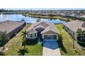 Single-story home, lakefront property with lush landscaping and a community view at 25281 E Lenox Cir, Punta Gorda, FL 33950