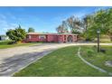 Pink ranch home with circular driveway and landscaped yard at 3360 Conway Blvd, Port Charlotte, FL 33952