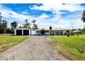 White Ranch house with detached garage and grassy yard at 3429 Sleepy Hollow Ln, Punta Gorda, FL 33950