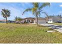 Single-story house with a two-car garage and palm trees at 413 San Ambrosio St, Punta Gorda, FL 33983