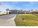 Inviting single-story home with a driveway, two-car garage, and mature landscaping in the front yard at 5194 Fleming St, Port Charlotte, FL 33981