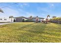 Well-kept lawn fronts this single-story home with a two-car garage and flowering bushes at 5194 Fleming St, Port Charlotte, FL 33981