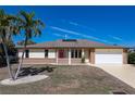 Single story home with red front door, attached garage, and landscaping at 520 Boardman Dr, Punta Gorda, FL 33950