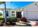 Welcoming front entry with a paved walkway and tropical landscaping at 5277 Shell Mound Cir, Punta Gorda, FL 33982