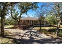 Gray house with wood deck and stone pathway, surrounded by lush trees at 5301 Sabal Palm Ln, Punta Gorda, FL 33982