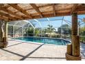 Inviting pool area with covered patio and lush landscaping at 121 Cambridge Nw Dr, Port Charlotte, FL 33952