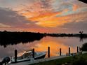 Stunning sunset over the calm waters with a boat at the dock at 1454 Surfbird Ct, Punta Gorda, FL 33950