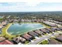 Aerial view of a neighborhood with houses surrounding a lake at 1840 Bobcat Trl, North Port, FL 34288