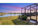 Screened-in patio area overlooking a lake at sunset at 1840 Bobcat Trl, North Port, FL 34288