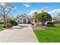 Single-story home with a tile roof, double door entry, and landscaped yard at 2209 Calusa Lakes Blvd, Nokomis, FL 34275