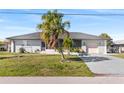 Single-story home with grey roof, palm trees, and carport at 312 E Tarpon Nw Blvd, Port Charlotte, FL 33952