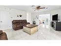 Bright living room with marble floors, brown leather couches, and a coffee table at 312 E Tarpon Nw Blvd, Port Charlotte, FL 33952