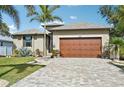 Single story home with paver driveway and lush landscaping at 316 Antis Dr, Rotonda West, FL 33947