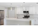 Spacious kitchen featuring white cabinets, quartz countertops, and stainless steel appliances at 509 Sunset N Rd, Rotonda West, FL 33947